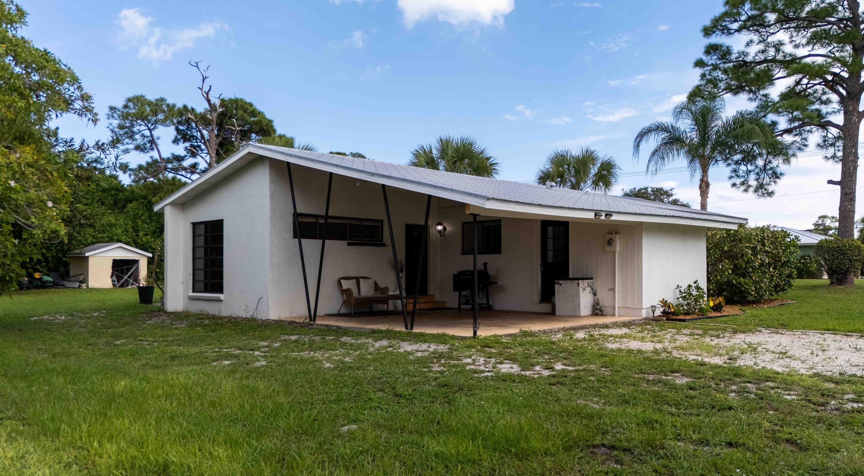 1849 Northwest Pine Tree Way Stuart, FL 34994 - Photo 24 of 29 a front view of house with yard and outdoor seating