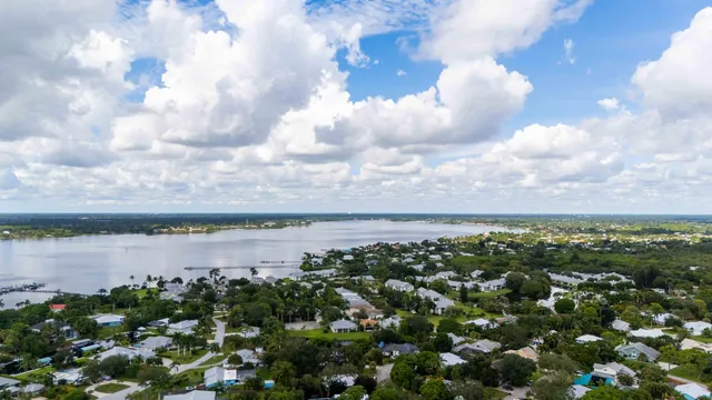 an aerial view of residential houses with outdoor space and lake view