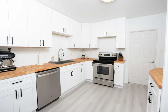 a kitchen with granite countertop white cabinets and white appliances