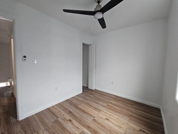 a view of an empty room with wooden floor