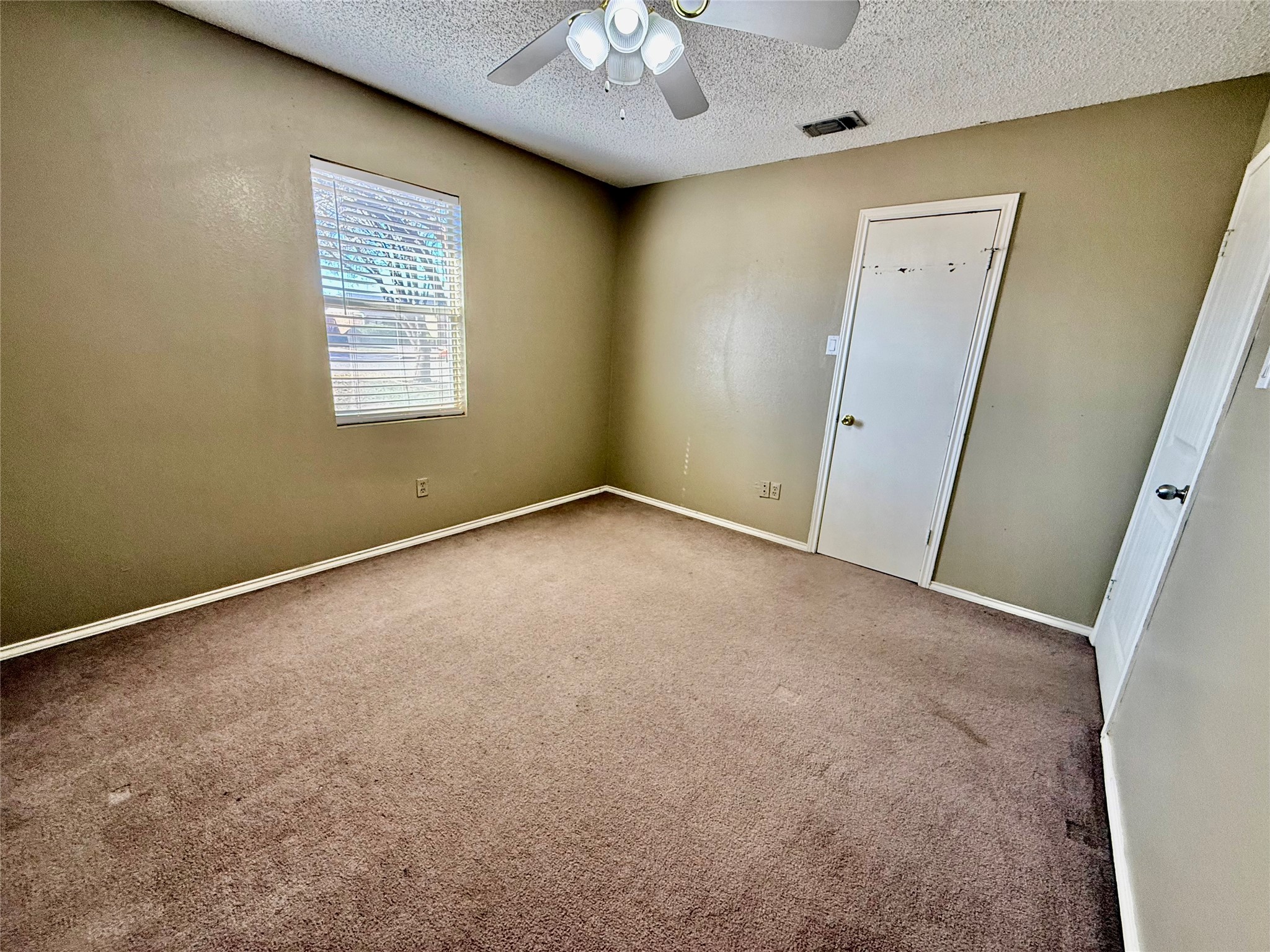 2206 87th Street Lubbock, TX 79423 - Photo 6 of 13 an empty room with a chandelier fan and windows