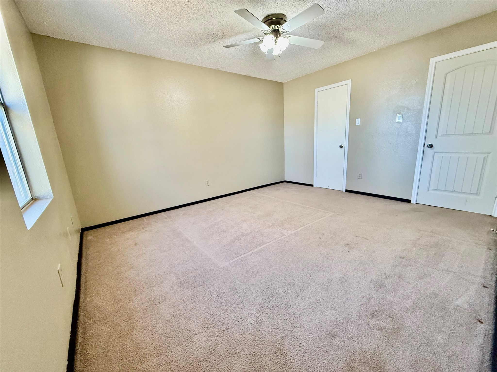 2206 87th Street Lubbock, TX 79423 - Photo 8 of 13 an empty room with a window and a fan