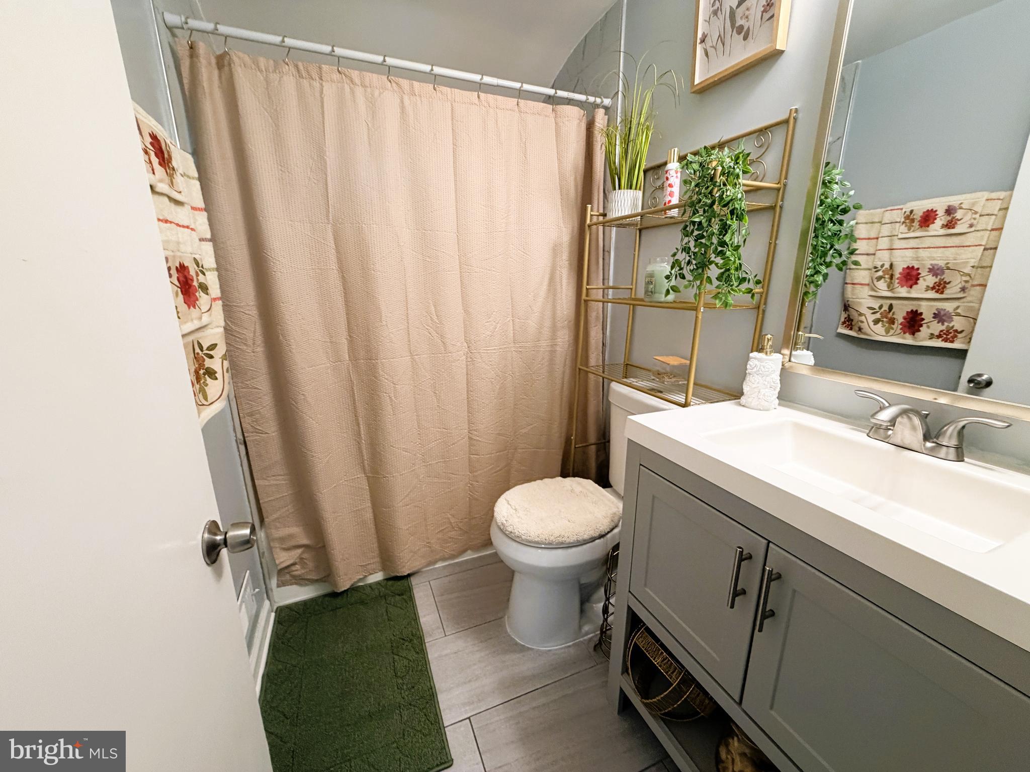 7403 S Road Rosedale, MD 21237 - Photo 17 of 27 a bathroom with a sink a toilet and shower curtain