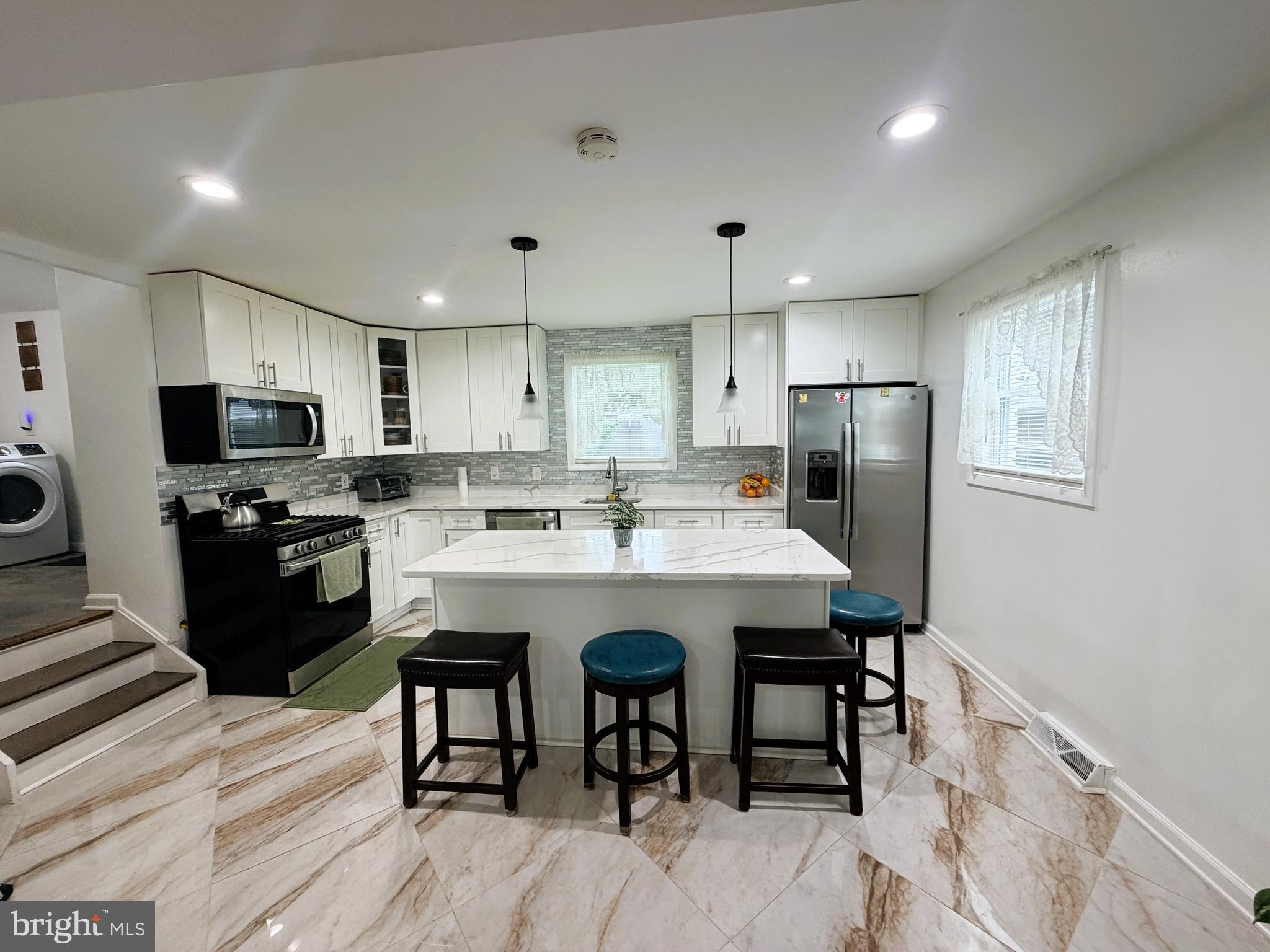 7403 S Road Rosedale, MD 21237 - Photo 9 of 27 a kitchen with stainless steel appliances granite countertop a refrigerator a stove top oven a sink dishwasher and wooden cabinets