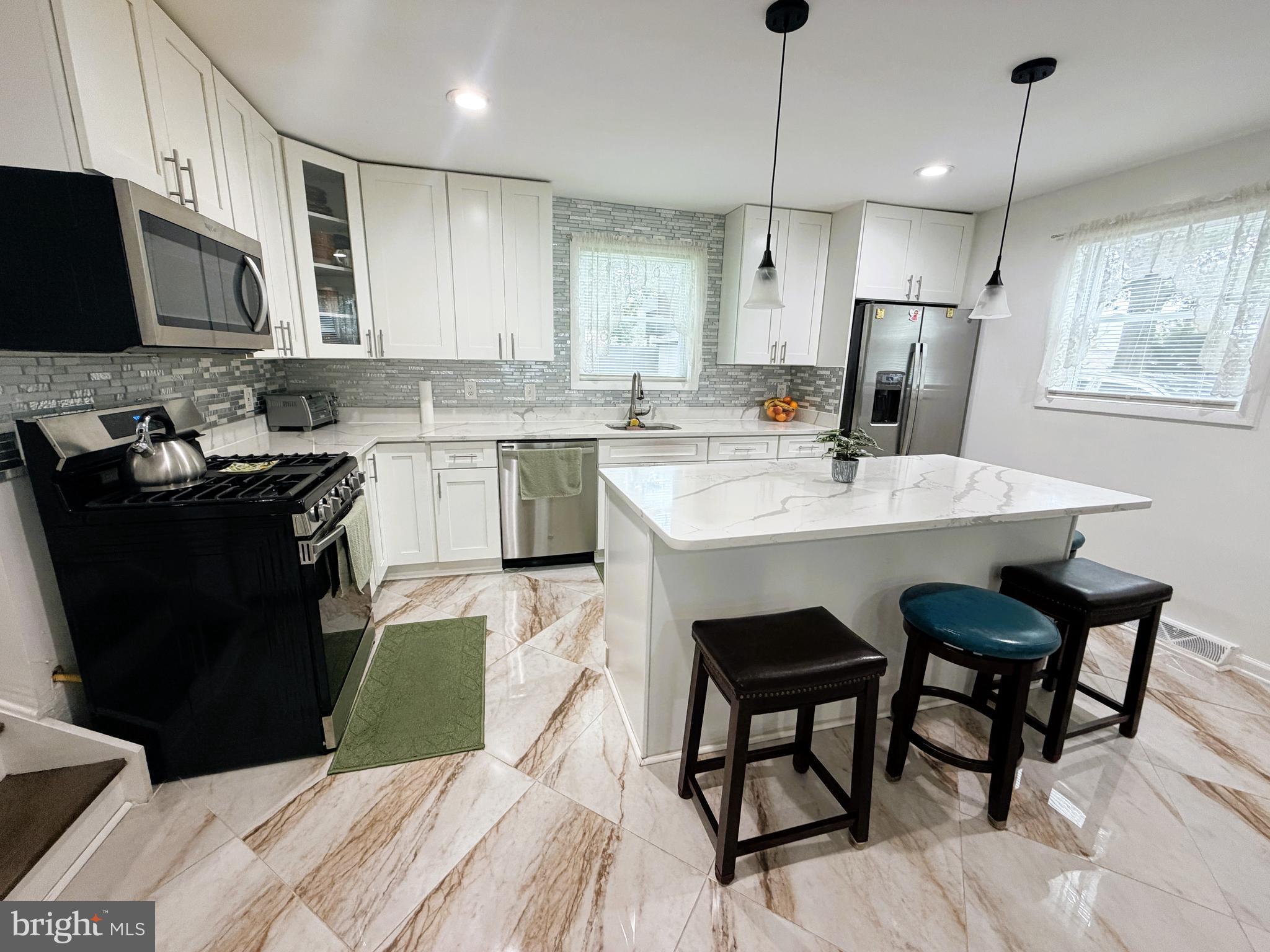 7403 S Road Rosedale, MD 21237 - Photo 10 of 27 a kitchen with a sink a microwave a stove and refrigerator