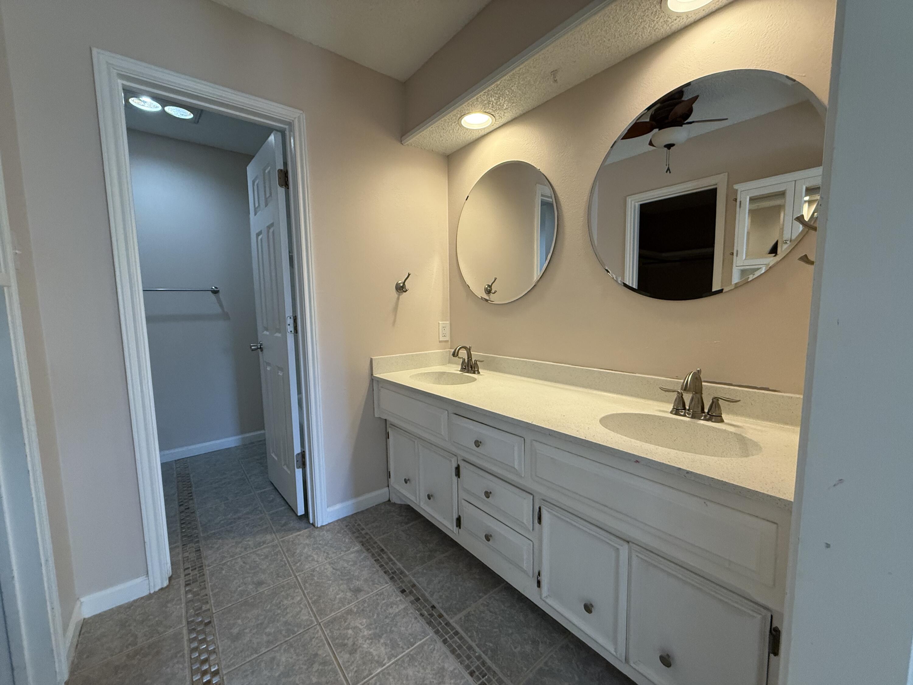 5729 89th Street Lubbock, TX 79424 - Photo 9 of 15 a spacious bathroom with a double vanity sink and a mirror