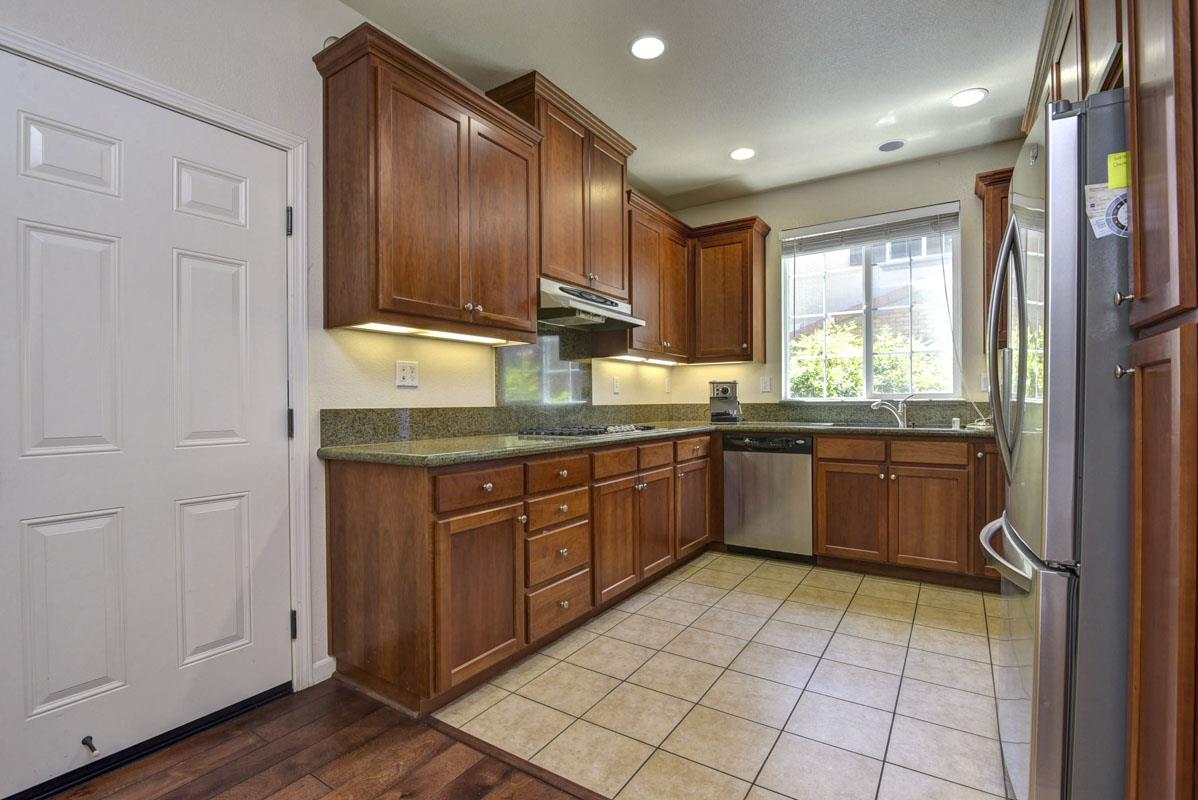 5373 Fioli Loop San Ramon, CA 94582 - Photo 7 of 31 a kitchen with stainless steel appliances granite countertop a refrigerator a sink dishwasher a stove with wooden cabinets and floor