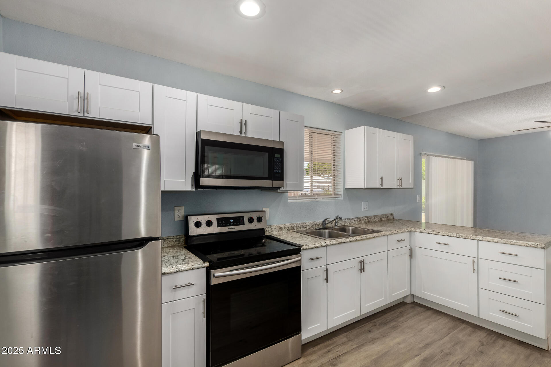 1510 South Lawther Drive Apache Junction, AZ 85120 - Photo 22 of 30 a kitchen with a refrigerator sink and white cabinets