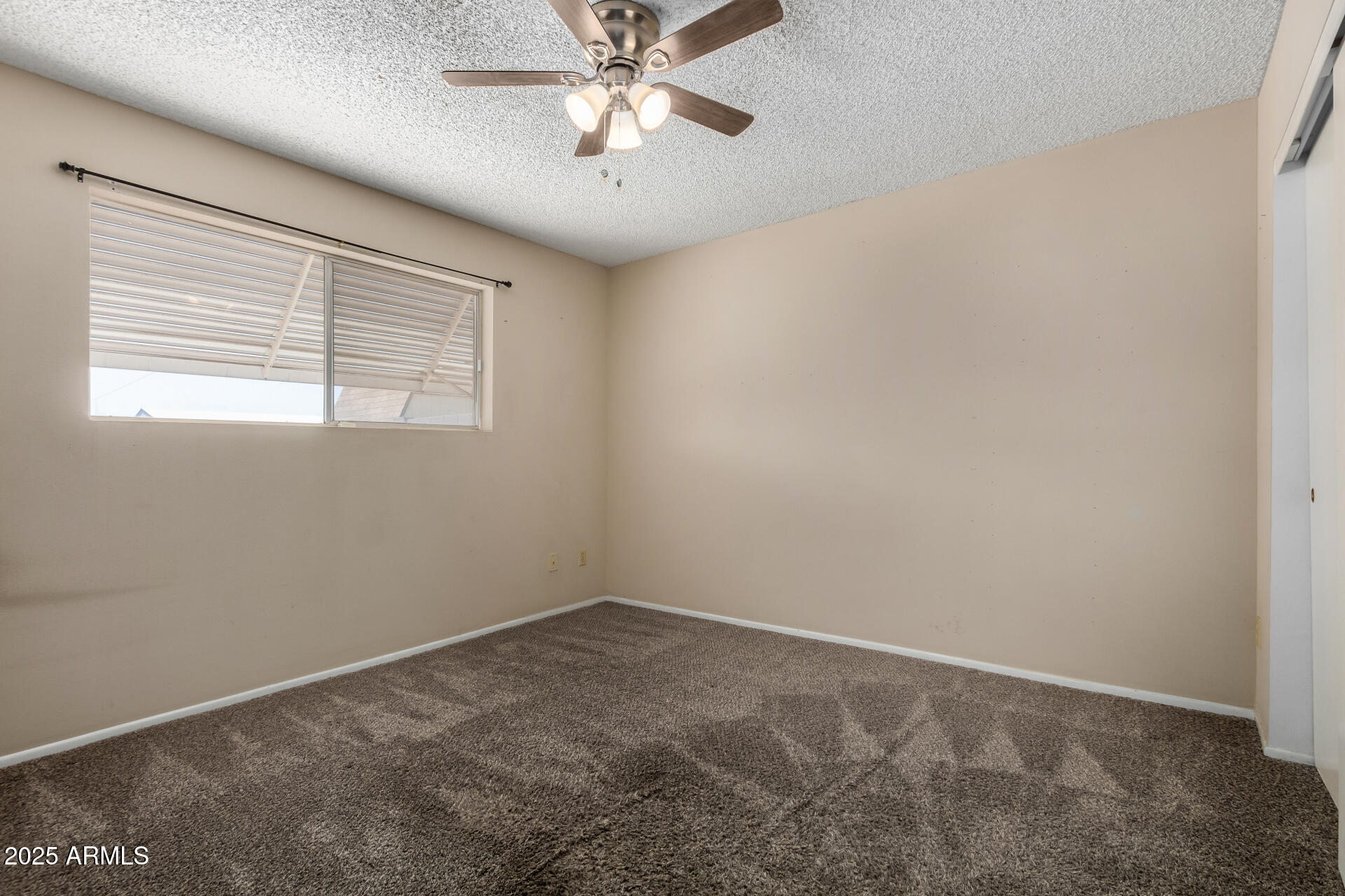 1510 South Lawther Drive Apache Junction, AZ 85120 - Photo 24 of 30 an empty room with a window and a fan