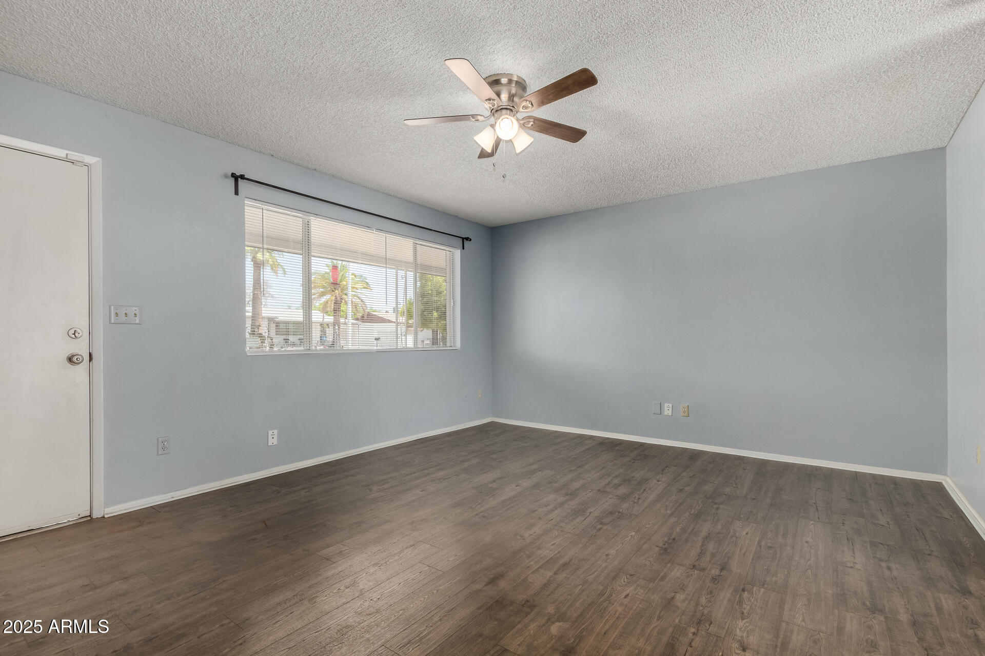 1510 South Lawther Drive Apache Junction, AZ 85120 - Photo 3 of 30 an empty room with wooden floor and ceiling fan