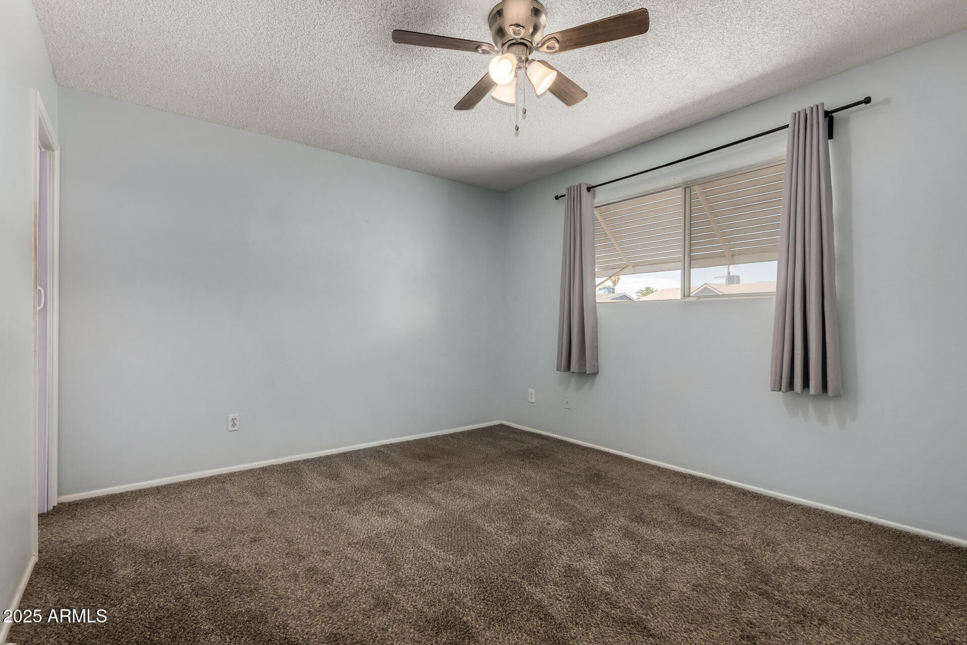 1510 South Lawther Drive Apache Junction, AZ 85120 - Photo 9 of 30 an empty room with windows and fan