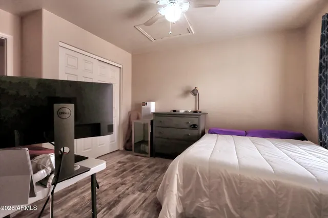 a bedroom with a bed and a flat tv screen on the dresser