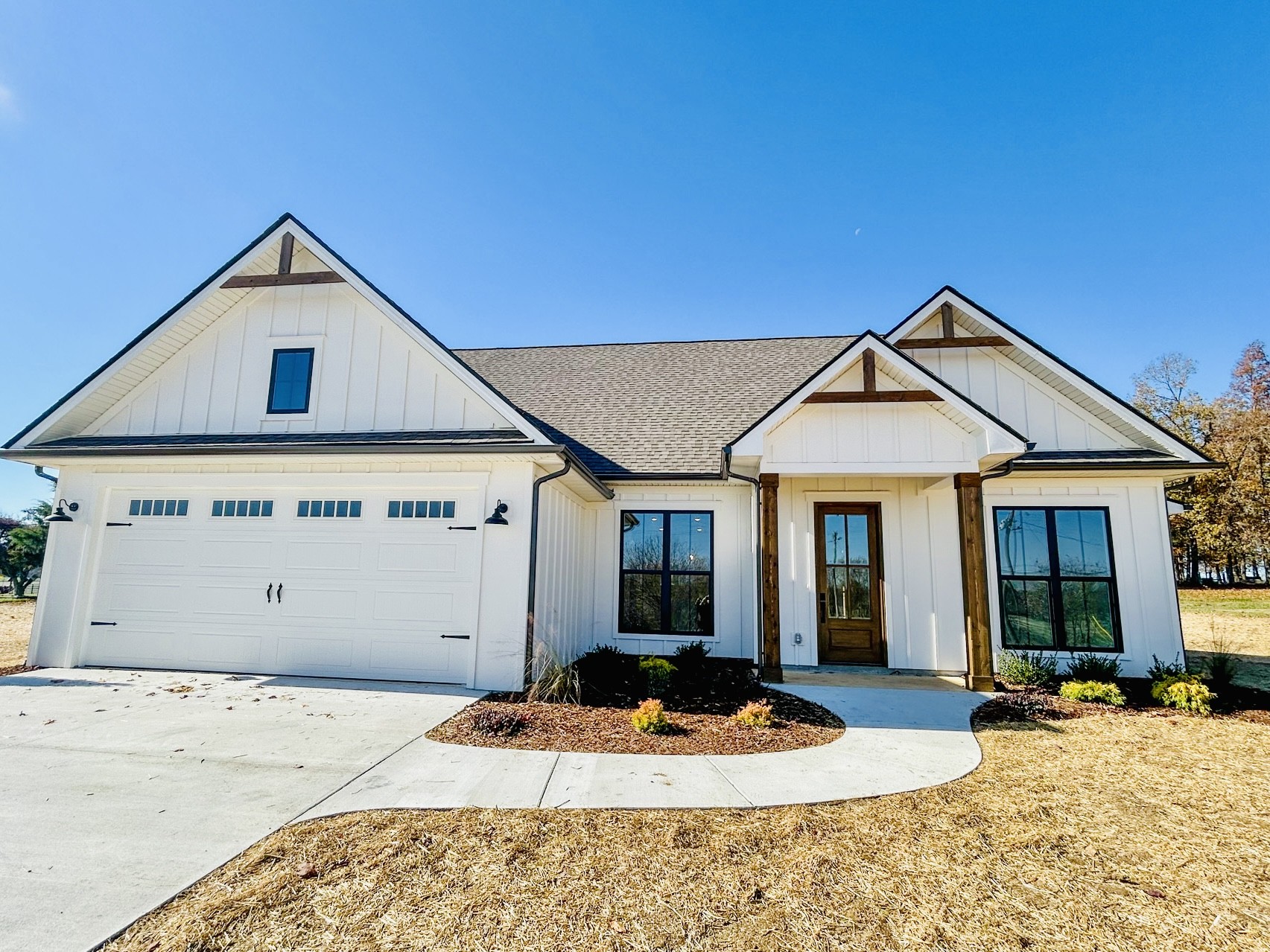 a view of a white house with a yard and plants