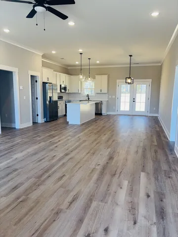 a view of a kitchen with kitchen island wooden floors appliances