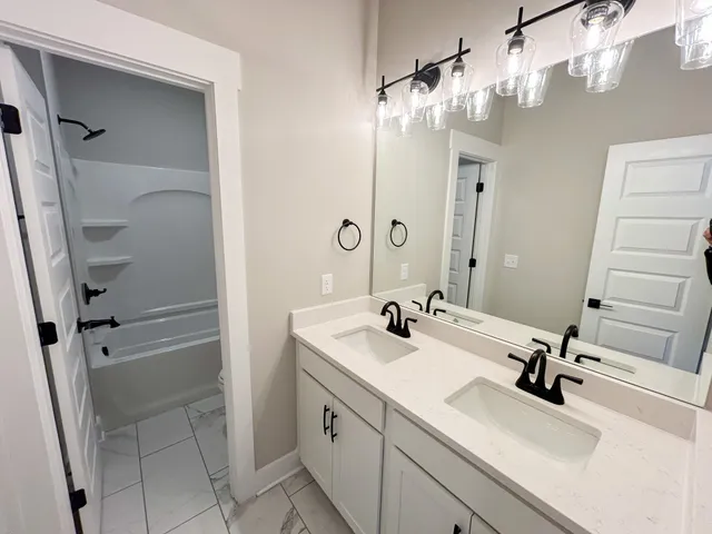 a bathroom with a sink a vanity a mirror and shower