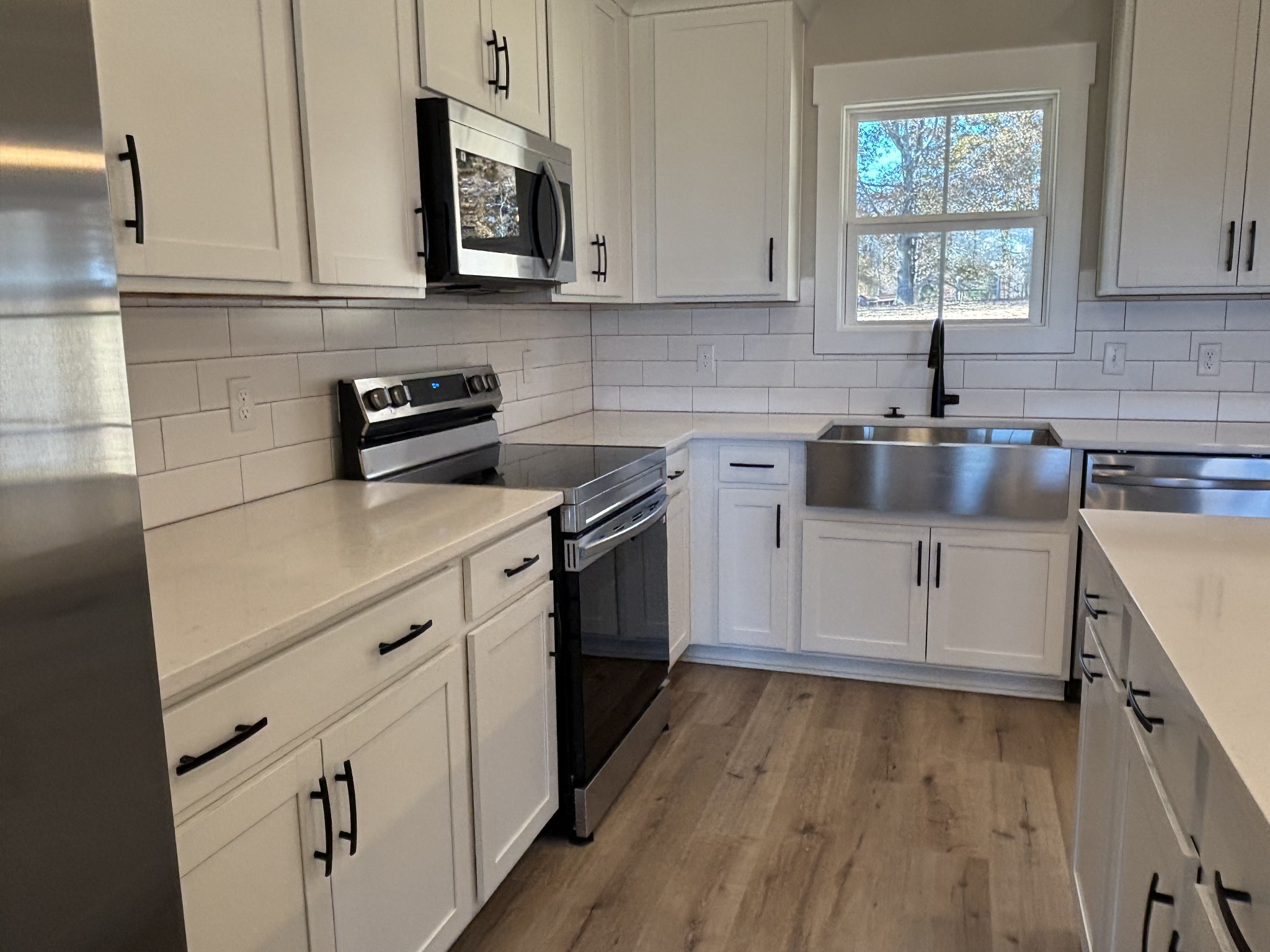 977 Hoodoo Road Beechgrove, TN 37018 - Photo 3 of 22 a kitchen with white cabinets appliances a sink and a window