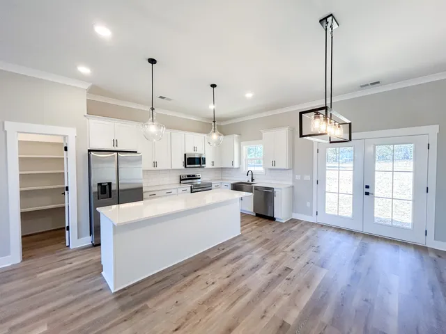 a large kitchen with cabinets wooden floor and stainless steel appliances