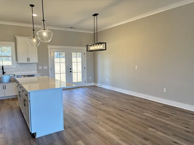 a view of a kitchen with a wooden floor and a ceiling fan