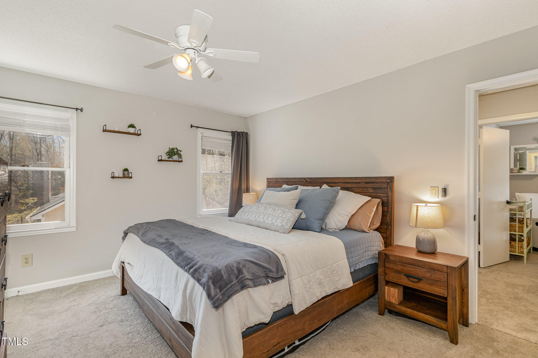 7708 Foxwood Drive Raleigh, NC 27615 - Photo 12 of 25 a bedroom with a large bed and a chandelier fan