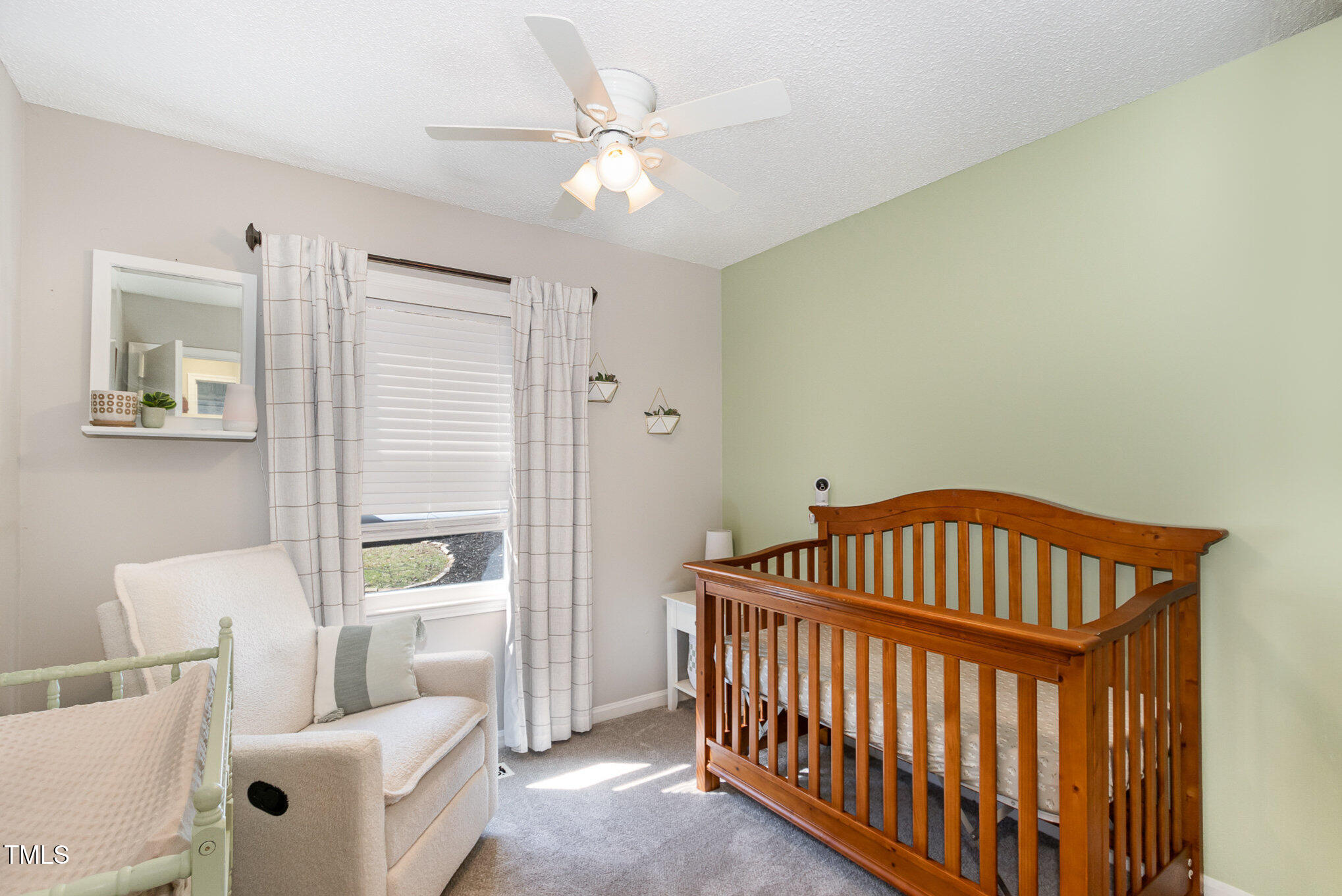 7708 Foxwood Drive Raleigh, NC 27615 - Photo 17 of 25 a bedroom with a bed and a chandelier