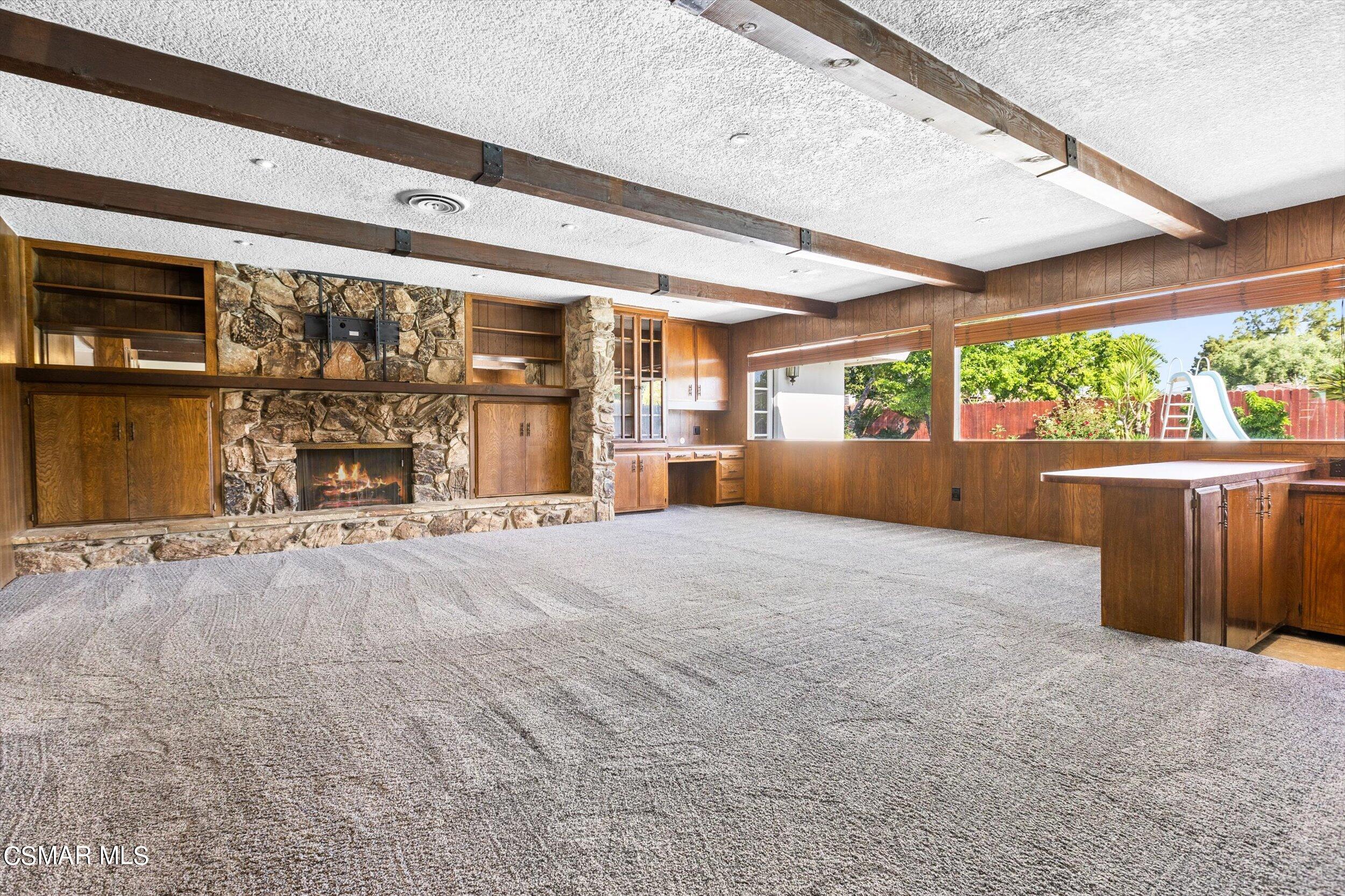 3512 Crest Drive Bakersfield, CA 93306 - Photo 13 of 40 an empty room with a fireplace and large windows