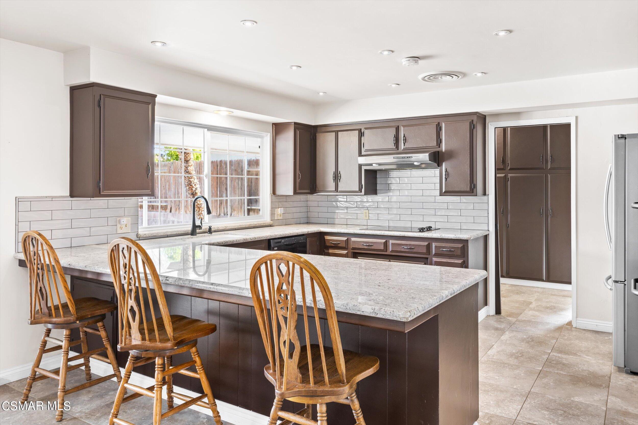 3512 Crest Drive Bakersfield, CA 93306 - Photo 21 of 40 a kitchen with a table chairs refrigerator and cabinets