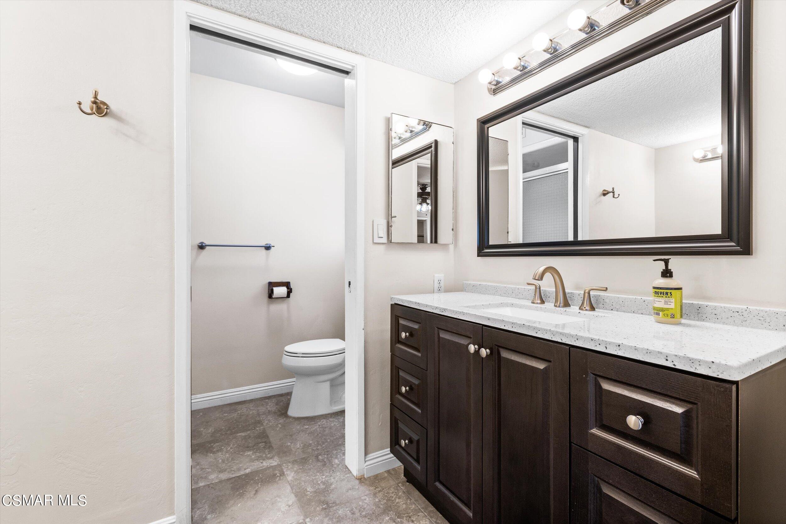 3512 Crest Drive Bakersfield, CA 93306 - Photo 28 of 40 a bathroom with a granite countertop sink toilet and mirror