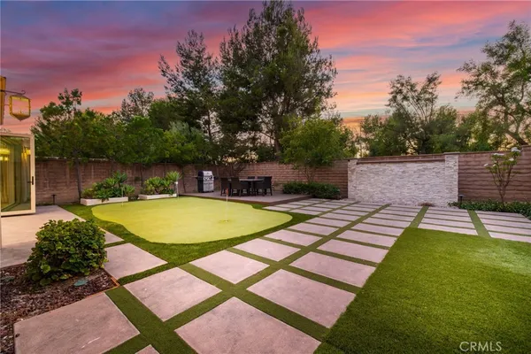a view of a backyard with swimming pool and sitting area