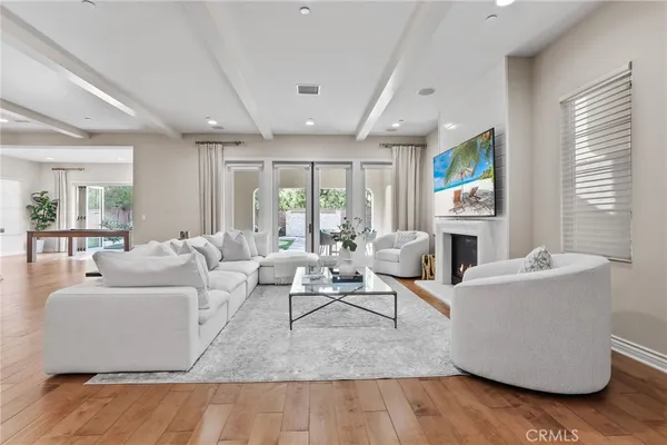 a living room with furniture wooden floor and a large window