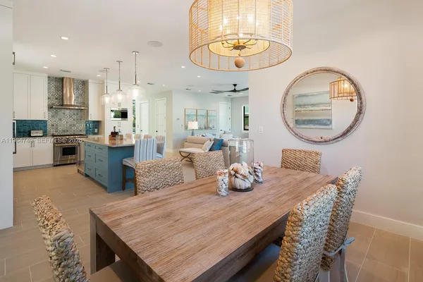 a dining room with wooden floor a chandelier a wooden table and chairs