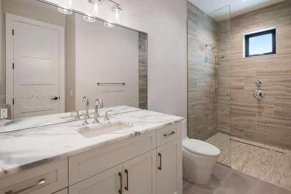 a bathroom with a sink a toilet and shower