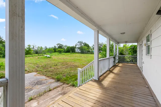 a view of a porch with wooden floor and wooden fence