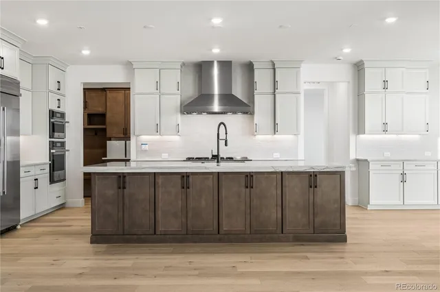 a kitchen with stainless steel appliances a sink cabinets and wooden floor