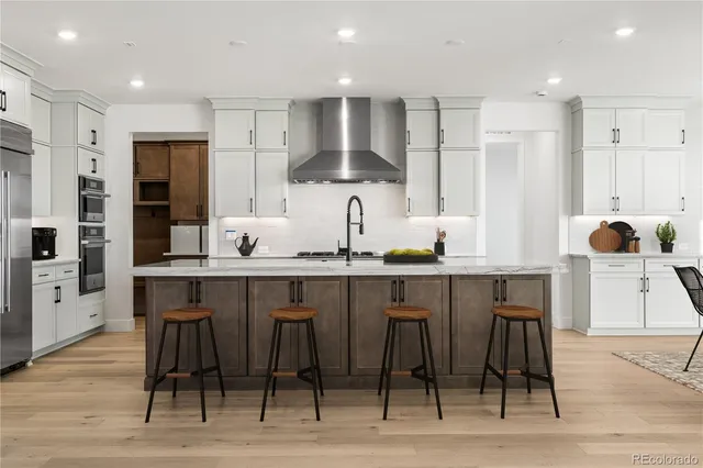 a kitchen with stainless steel appliances kitchen island granite countertop a table chairs sink and cabinets