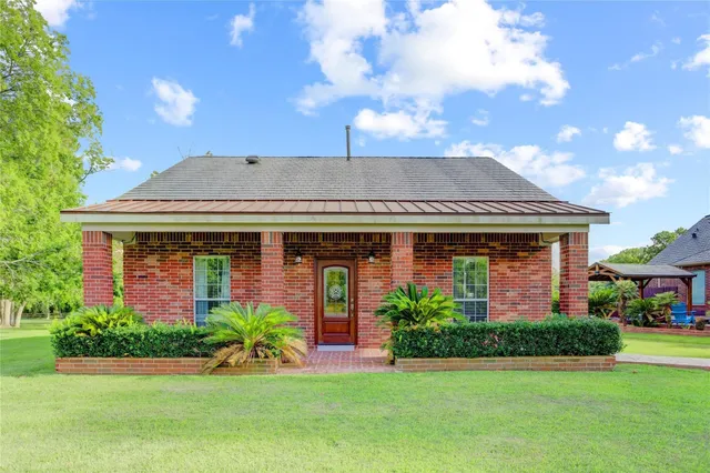 a front view of a house with a yard and potted plants