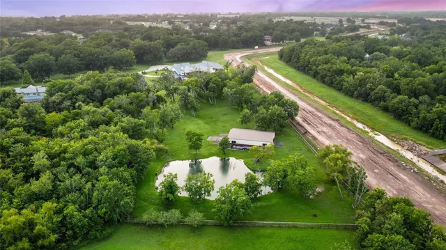 an aerial view of residential houses with outdoor space and trees