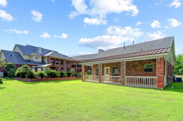 a view of a house with a yard and potted plants