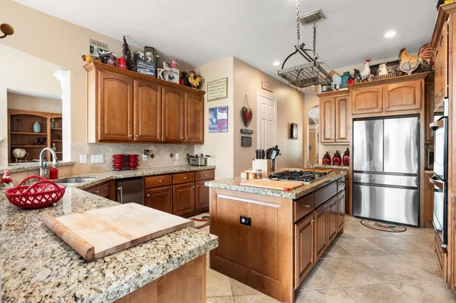 a kitchen with granite countertop a sink stainless steel appliances and cabinets