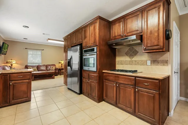 a kitchen with stainless steel appliances granite countertop a stove top oven sink and cabinets