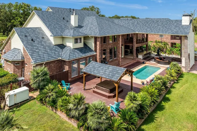 an aerial view of house with yard and patio