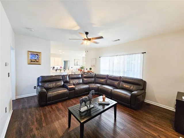 a living room with furniture a ceiling fan and a rug