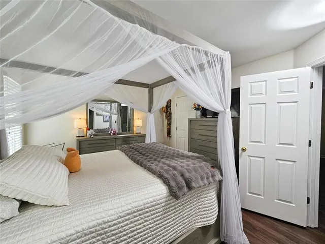 a bedroom with a large bed wooden floor and window
