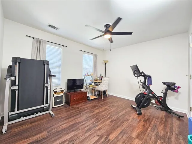 a view of a room with wooden floor and ceiling fan
