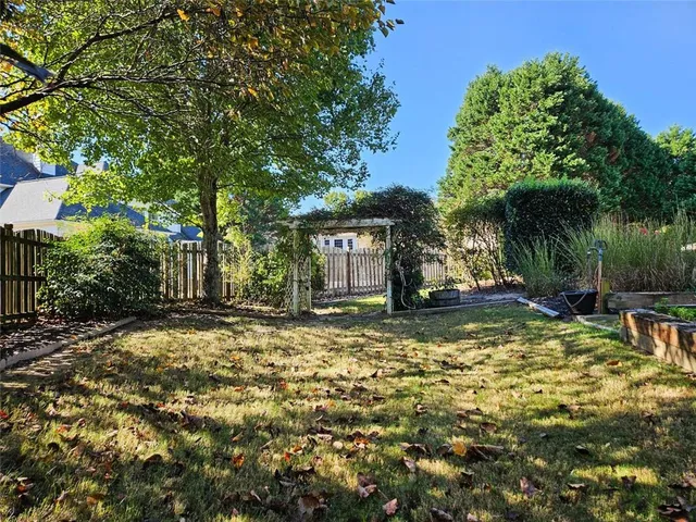 a view of backyard with potted plants and wooden fence