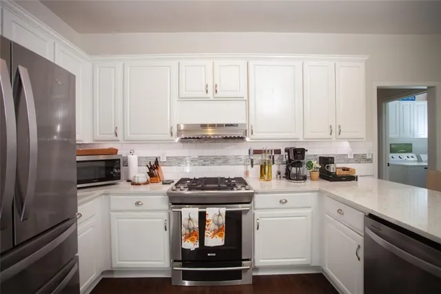 a kitchen with stainless steel appliances a stove microwave and cabinets