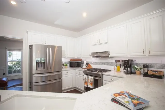 a kitchen with stainless steel appliances and a refrigerator