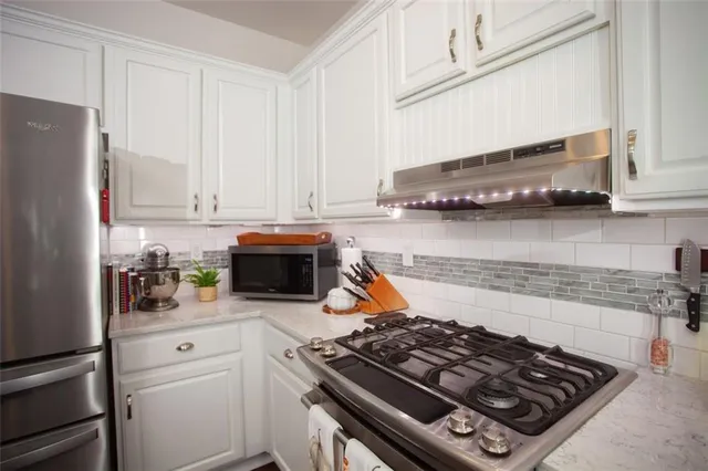 a kitchen with stainless steel appliances granite countertop a stove and a refrigerator