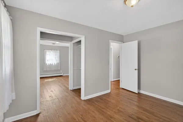 a view of an empty room with wooden floor