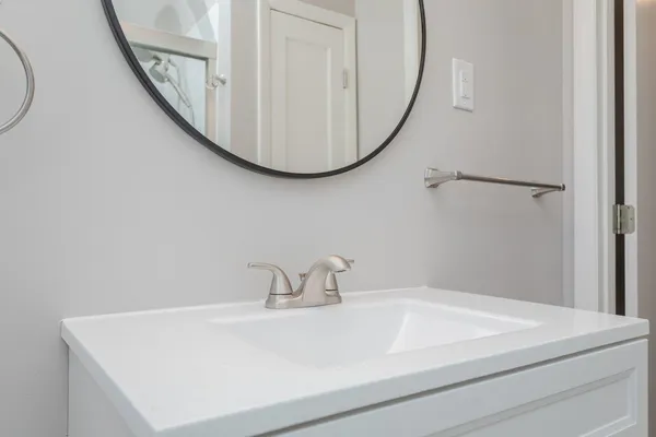 a bathroom with a toilet mirror vanity and a sink