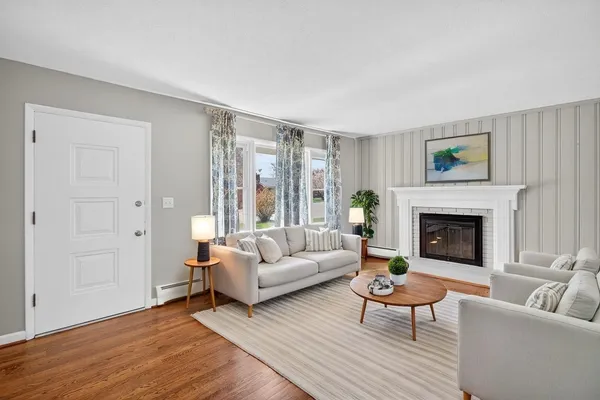 an empty room with wooden floor fireplace and windows